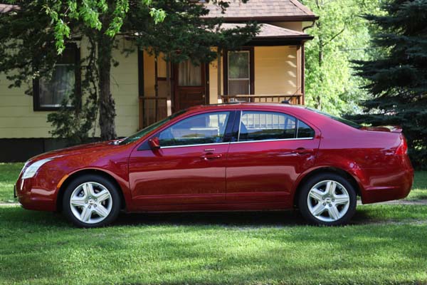 Here is a side view of my New Mercury Milan.  By the way, that creepy looking old house in the background is mime.